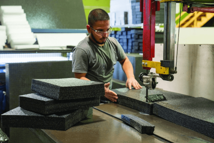 Larson Packaging Company team member cutting foam to size in the factory